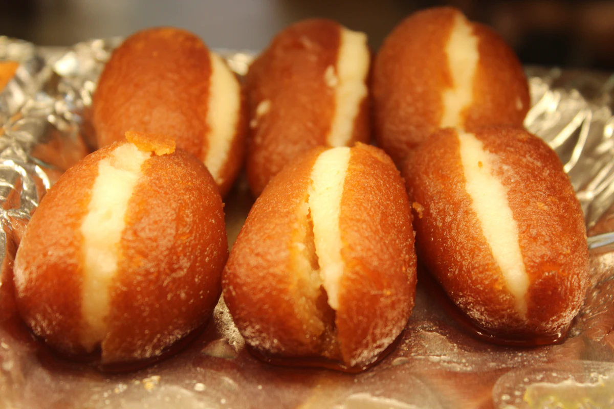 Brown gulab jamun split open and filled with white cream.